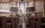 Public officials disinfect pews as a precaution against the coronavirus at the Yoido Full Gospel Church in Seoul, South Korea, Aug. 21, 2020 (AP Photo/Ahn Young-joon)