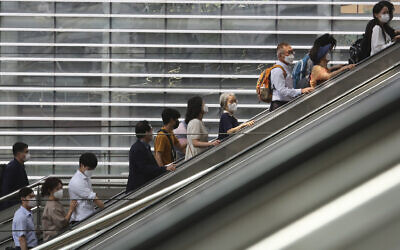 People wearing face masks to help protect against the spread of the coronavirus ride an escalator as they arrive at the Seoul Railway Station in Seoul, South Korea, August 24, 2020. (AP Photo/Ahn Young-joon)