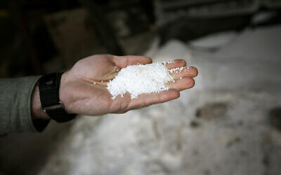 Illustrative: A man holds ammonium nitrate as he stands by a pile of the product, December 12, 2013, in Clifton, Texas. (Tony Gutierrez/AP)