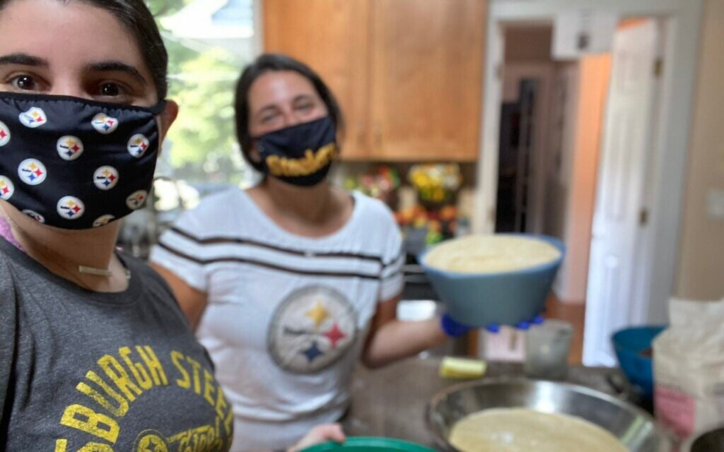Hannah (left) and Sara Loffman baking challah for the Challah Back Girls project. (Courtesy)