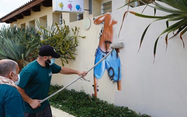 Tel Aviv Municipality workers remove a mural of boys peeping into the women's changing room at Metzitzim beach in Tel Aviv, August 23, 2020. (Ron Huldai/ Twitter) Tel Aviv Municipality workers remove a mural of boys peeping into the women's changing room at Metzitzim beach in Tel Aviv, August 23, 2020. (Ron Huldai/ Twitter)