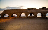 ILLUSTRATIVE -- People sit on the arches of Caesarea Beach on June 15, 2017 (Anat Hermony/FLASH90)