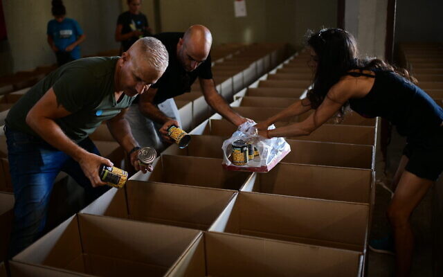 Israelis pack food packages for the needy ahead of Rosh Hashana, on September 25, 2019, in Tel Aviv. (Tomer Neuberg/Flash90) Israelis pack food packages for the needy ahead of Rosh Hashana, on September 25, 2019, in Tel Aviv. (Tomer Neuberg/Flash90)