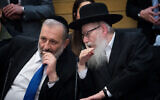 Shas party chairman and Interior Affairs Minister, Aryeh Deri, left, speaks with United Torah Judaism party leader, then health minister, Yaakov Litzman in the Knesset, March 4, 2020. (Yonatan Sindel/ Flash90)