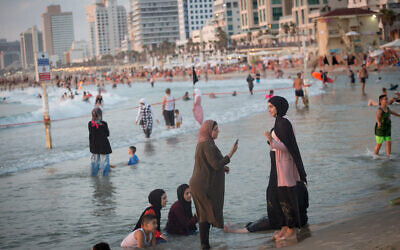 Arab women enjoy the beach in Tel Aviv on August 4, 2020. (Miriam Alster/Flash90)