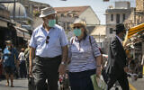 Israelis, wearing face masks for fear of the coronavirus, shop at the Mahane Yehuda market in Jerusalem on August 4, 2020. (Olivier Fitoussi/Flash90)