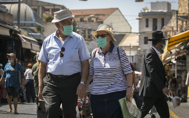 Israelis, wearing face masks for fear of the coronavirus, shop at the Mahane Yehuda market in Jerusalem on August 4, 2020. (Olivier Fitoussi/Flash90) Israelis, wearing face masks for fear of the coronavirus, shop at the Mahane Yehuda market in Jerusalem on August 4, 2020. (Olivier Fitoussi/Flash90)