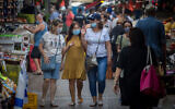 Israelis wear protective face masks as they shop for food at the Carmel market in Tel Aviv on August 5, 2020. (Miriam Alster/FLASh90)