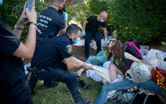 Jerusalem municipality workers and police officers seen evacuating demonstrators who built a protest tent camp, against Prime Minister Benjamin Netanyahu, in Independence Park, Jerusalem, August 9, 2020. (Yonatan Sindel/Flash90)
