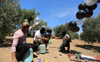 Palestinians prepare an indenciary to be flown toward Israel by balloon, near the Israel-Gaza border, in the eastern part of the Gaza Strip, August 10, 2020. (Abed Rahim Khatib/Flash90)