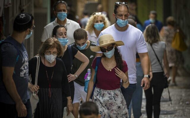 People wearing face masks due to coronavirus outbreak walk in the Old City of Jerusalem on August 10, 2020. (Olivier Fitoussi/Flash90) People wearing face masks due to coronavirus outbreak walk in the Old City of Jerusalem on August 10, 2020. (Olivier Fitoussi/Flash90)