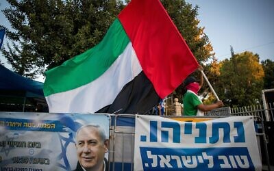 A man waves a large United Arab Emirates flag outside the Prime Minister's Residence in Jerusalem on August 19, 2020. (Yonatan Sindel/Flash90)
