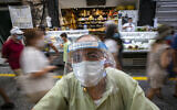 Israelis, wearing face masks for fear of the coronavirus, shop for grocery at the Mahane Yehuda market in Jerusalem on August 20, 2020. (Olivier Fitoussi/Flash90)