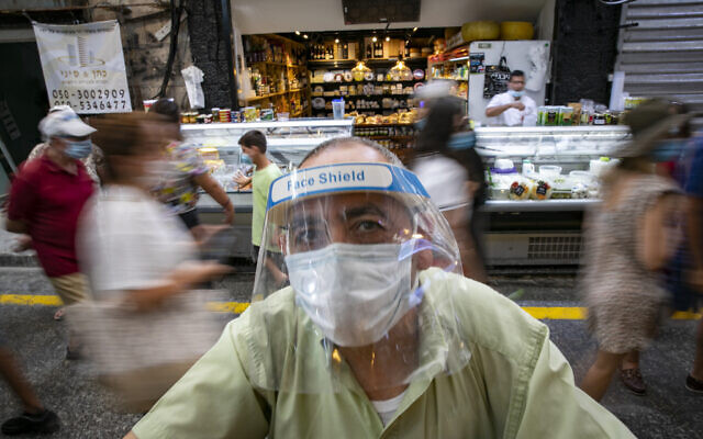 Israelis, wearing face masks for fear of the coronavirus, shop for grocery at the Mahane Yehuda market in Jerusalem on August 20, 2020. (Olivier Fitoussi/Flash90) Israelis, wearing face masks for fear of the coronavirus, shop for grocery at the Mahane Yehuda market in Jerusalem on August 20, 2020. (Olivier Fitoussi/Flash90)