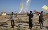 Palestinians near Rafah in the southern Gaza Strip prepare to release balloon-borne explosive and incendiary devices towards Israel on August 21, 2020. (Fadi Fahd/Flash90)