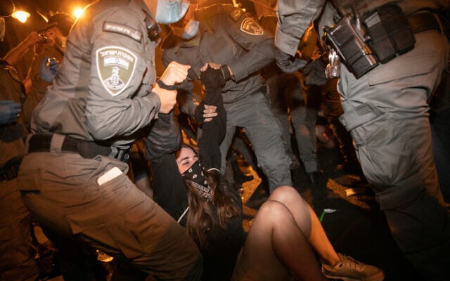 Police officers remove demonstrators during a protest against Prime Minister Benjamin Netanyahu, outside the Prime Minister's Residence, in Jerusalem on August 22, 2020. (Olivier Fitoussi/Flash90) Police officers remove demonstrators during a protest against Prime Minister Benjamin Netanyahu, outside the Prime Minister's Residence, in Jerusalem on August 22, 2020. (Olivier Fitoussi/Flash90)