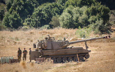 Israeli soldiers stand near artillery howitzers deployed near the Lebanese border in northern Israel on August 26, 2020. (David Cohen/Flash90)