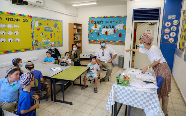First-grade students and their parents in a classroom ahead of the opening of the school year at Orot Etzion School, in the West Bank settlement of Efrat, August 30, 2020. (Gershon Elinson/Flash90) First-grade students and their parents in a classroom ahead of the opening of the school year at Orot Etzion School, in the West Bank settlement of Efrat, August 30, 2020. (Gershon Elinson/Flash90)