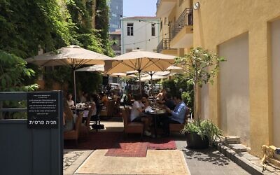 The Hotel Montefiore in Tel Aviv turned its parking lot into an outdoor dining space during the coronavirus summer season, July 2020 (Jessica Steinberg/Times of Israel)
