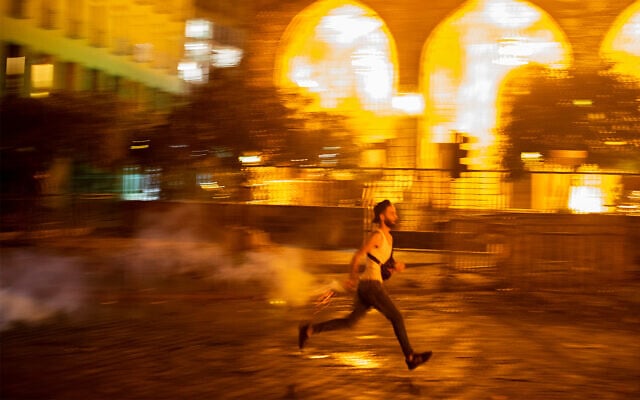 An anti-government protester throws back a tear gas canister at riot police, during a protest against the political elites who have ruled the country for decades, in Beirut, Lebanon, August 7, 2020. (AP Photo/Hassan Ammar) An anti-government protester throws back a tear gas canister at riot police, during a protest against the political elites who have ruled the country for decades, in Beirut, Lebanon, August 7, 2020. (AP Photo/Hassan Ammar)