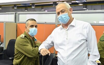 Defense Minister Benny Gantz (right) bumps elbows with Brig. Gen. Nissan Davidi, who was tasked with leading the military's Coronavirus Command on August 4, 2020. (Ariel Hermoni/Defense Ministry)