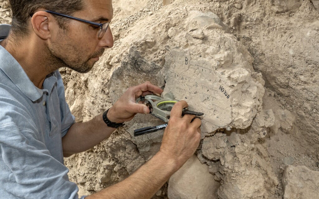 TAU PhD student Yoav Vaknin takes measurements of a floor that collapsed during the 586 BCE destruction of Jerusalem by the Babylonians at excavations in the City of David Park in Jerusalem. (Shai Halevi/Israel Antiquities Authority)