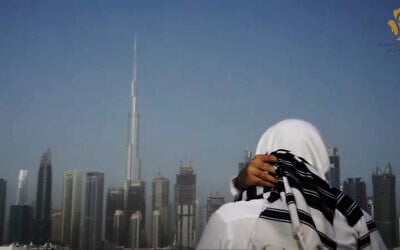 A man sporting a Jewish 'tallit' looks out over the Dubai skyline in the United Arab Emirates (video screenshot)