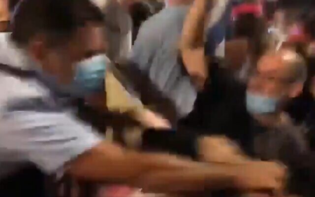 Jerusalem Chief Superintendent Niso Guetta is seen in video as he shoves and hits protesters, August 22, 2020 (Screen grab/Kan) Jerusalem Chief Superintendent Niso Guetta is seen in video as he shoves and hits protesters, August 22, 2020 (Screen grab/Kan)