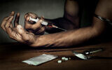 A man with a syringe used to inject heroin (iStock)