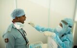 An Indian COVID-19 patient provides samples to a medic helping Israel's coronavirus mission to India. (Defense Ministry Spokesperson’s Office)