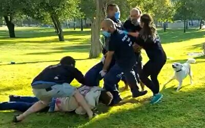 Protesters try to stop municipal officials from confiscating equipment from anti-Netanyahu encampment in Independence Park, Jerusalem, August 9, 2020. (screen grab/Kan)