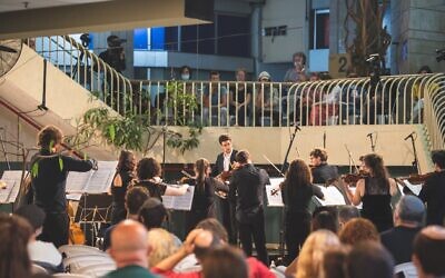Ido Shpitalnik, conductor of the Jerusalem Street Orchestra, performing at the one concert he's been allowed to hold since the start of the coronavirus. (courtesy, Jerusalem Street Orchestra)
