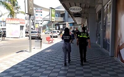 Police officers at the Bilu shopping center after stores opened in defiance of regulations, August 1, 2020 (Screen grab/Channel 12 news)