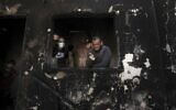Palestinian man Omar al-Hazeen (R) reacts at his torched house where his three children were killed in a fire ignited by a candle used to light up their room during a power cut in al-Nusirat refugee camp in the central Gaza Strip on September 2, 2020. In response to the persistent arson balloon launches from the Gaza Strip, Israel has banned fishing off Gaza's coast and closed the Kerem Shalom goods crossing, cutting off deliveries of fuel to the territory's sole power plant. Power had been in short supply even before the shutdown, with consumers having access to mains electricity for only around eight hours a day. (MAHMUD HAMS / AFP)