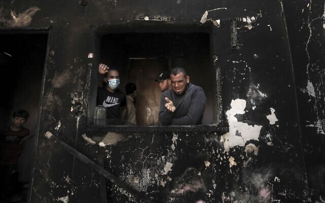 Palestinian man Omar al-Hazeen (R) reacts at his torched house where his three children were killed in a fire ignited by a candle used to light up their room during a power cut in al-Nusirat refugee camp in the central Gaza Strip on September 2, 2020. In response to the persistent arson balloon launches from the Gaza Strip, Israel has banned fishing off Gaza's coast and closed the Kerem Shalom goods crossing, cutting off deliveries of fuel to the territory's sole power plant. Power had been in short supply even before the shutdown, with consumers having access to mains electricity for only around eight hours a day. (MAHMUD HAMS / AFP) Palestinian man Omar al-Hazeen (R) reacts at his torched house where his three children were killed in a fire ignited by a candle used to light up their room during a power cut in al-Nusirat refugee camp in the central Gaza Strip on September 2, 2020. In response to the persistent arson balloon launches from the Gaza Strip, Israel has banned fishing off Gaza's coast and closed the Kerem Shalom goods crossing, cutting off deliveries of fuel to the territory's sole power plant. Power had been in short supply even before the shutdown, with consumers having access to mains electricity for only around eight hours a day. (MAHMUD HAMS / AFP)