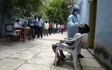 Residents stand in a queue to register their names as a health worker collects a swab sample to test for the coronavirus, at a primary health center in Hyderabad on September 4, 2020. (NOAH SEELAM / AFP)