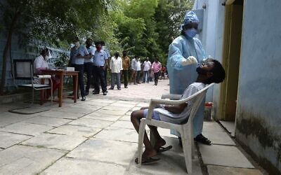 Residents stand in a queue to register their names as a health worker collects a swab sample to test for the coronavirus, at a primary health center in Hyderabad on September 4, 2020. (NOAH SEELAM / AFP) Residents stand in a queue to register their names as a health worker collects a swab sample to test for the coronavirus, at a primary health center in Hyderabad on September 4, 2020. (NOAH SEELAM / AFP)
