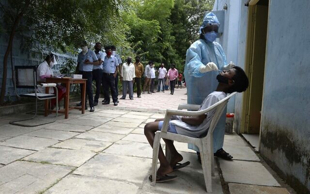 Residents stand in a queue to register their names as a health worker collects a swab sample to test for the coronavirus, at a primary health center in Hyderabad on September 4, 2020. (NOAH SEELAM / AFP) Residents stand in a queue to register their names as a health worker collects a swab sample to test for the coronavirus, at a primary health center in Hyderabad on September 4, 2020. (NOAH SEELAM / AFP)