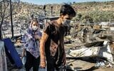 Migrants walk inside the burnt Moria Camp on the Greek island of Lesbos on September 9, 2020, after a major fire. (Anthi PAZIANOU / AFP)