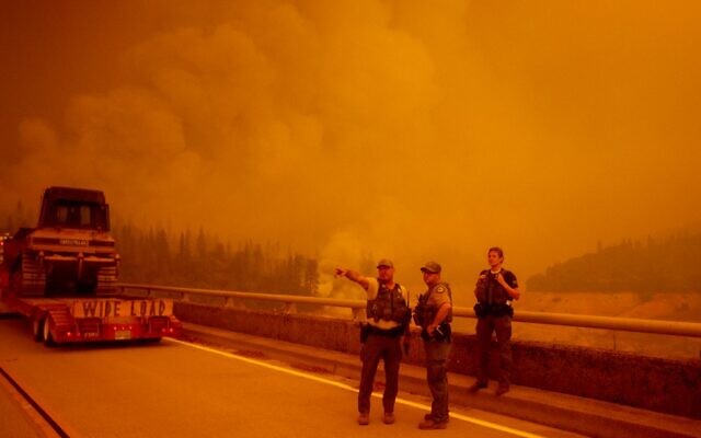 Law enforcement and fire personnel wait on the Enterprise Bridge to enter an area encroached by fire during the Bear fire, part of the North Lightning Complex fires, in unincorporated Butte County, in Oroville, California on September 9, 2020 (JOSH EDELSON / AFP)
