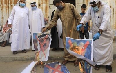 Palestinian men burn the exed-out portraits of the Bahraini king, US president and Israeli premier during a protest in Deir al-Balah, in the central Gaza Strip, on September 12, 2020. (MAHMUD HAMS / AFP)