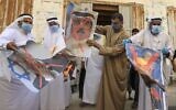 Palestinian men burn portraits of Bahraini King Hamad bin Isa Al Khalifa, US President Donald Trump and Prime Minister Benjamin Netanyahu during a rally organized by Hamas in the central Gaza city of Deir al-Balah on September 12, 2020, to condemn the Israel-Bahrain normalization agreement. (Mahmud Hams/AFP)