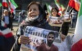 A woman holds a portrait of Iranian wrestler Navid Afkari during a demonstration on the Dam Square in Amsterdam, the Netherlands, on September 13, 2020, against its execution in the southern Iranian city of Shiraz and against the Iranian government. (Evert Elzinga / ANP / AFP)