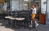An employee puts away the furniture of a restaurant in the coastal city of Tel Aviv on September 18, 2020, ahead of a nationwide lockdown to tackle a spike in coronavirus cases. (JACK GUEZ/AFP)