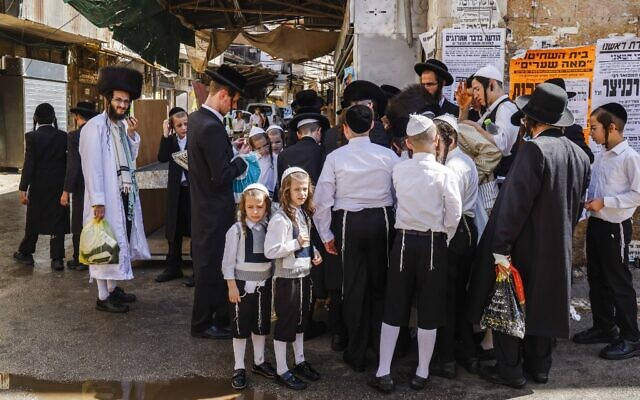 Ultra-Orthodox Jewish men and boys, a few mask-clad due to the coronavirus pandemic, stand along a street corner in the neighborhood of Mea Shearim in Jerusalem a few hours before the start of Yom Kippur, on September 27, 2020 (MENAHEM KAHANA / AFP) Ultra-Orthodox Jewish men and boys, a few mask-clad due to the coronavirus pandemic, stand along a street corner in the neighborhood of Mea Shearim in Jerusalem a few hours before the start of Yom Kippur, on September 27, 2020 (MENAHEM KAHANA / AFP)