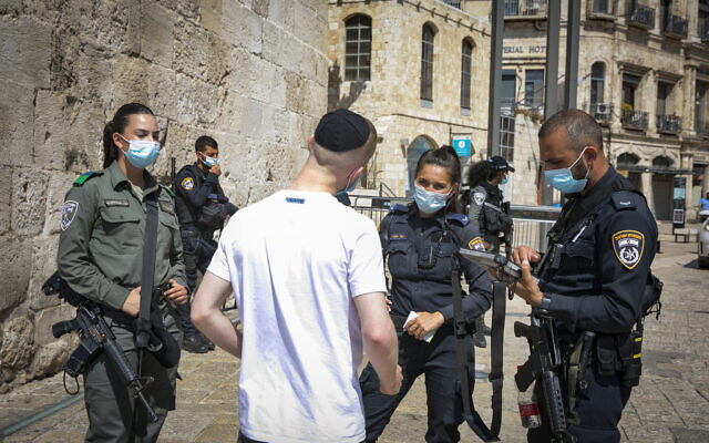 Police fine a man for violating the national lockdown rules at the Jaffa Gate in the Old City of Jerusalem on September 24, 2020. (Olivier Fitoussi/Flash90)