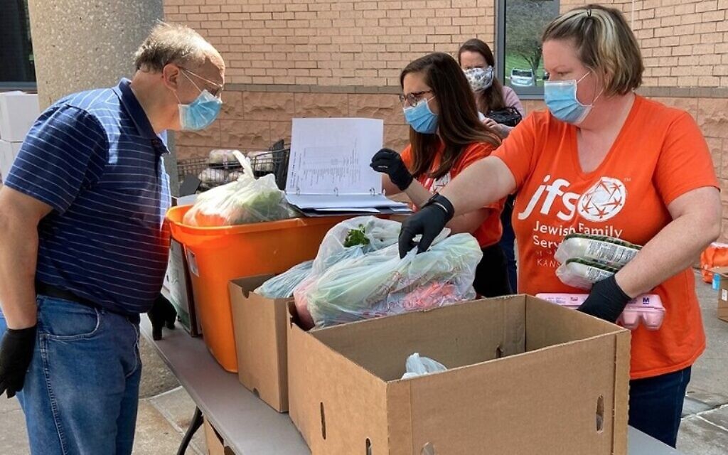 Food pantry volunteers work outside at the Jewish Federation of Kansas City amid the adoption of new pandemic-era health-and-safety protocols by Jewish institutions around the country. (Courtesy of JFGKC via JTA) Food pantry volunteers work outside at the Jewish Federation of Kansas City amid the adoption of new pandemic-era health-and-safety protocols by Jewish institutions around the country. (Courtesy of JFGKC via JTA)