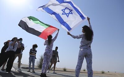 Israeli model May Tager, right, holds Israel's blue-and-white flag bearing the Star of David, while next to her Anastasia Bandarenka, a Dubai-based model originally from Russia, waves the Emirati flag, during a photo shoot in Dubai, United Arab Emirates, Sept. 8, 2020. (AP Photo/Kamran Jebreili)
