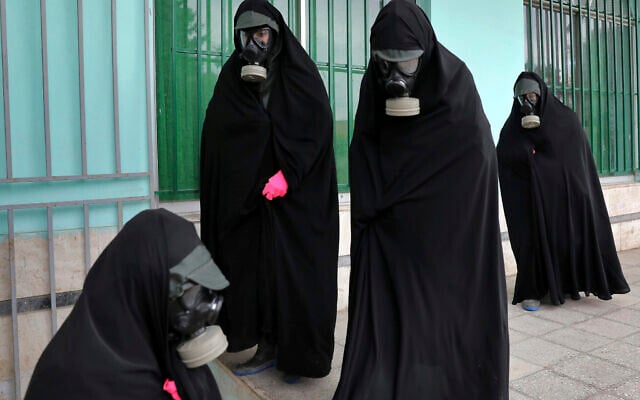 Cleric women wearing protective clothing and 'chador,' a head-to-toe garment, arrive a cemetery to prepare the body of a victim who died from the new coronavirus for a funeral, in the city of Ghaemshahr, in north of Iran, Thursday, April 30, 2020. (AP/Ebrahim Noroozi)
