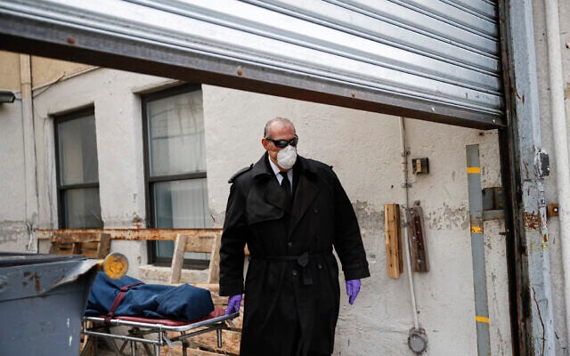Funeral director Tom Cheeseman wears personal protective equipment due to COVID-19 concerns as he collects a body from a nursing home, Friday, April 3, 2020, in the Brooklyn borough of New York. 'We took a sworn oath to protect the dead, this is what we do,' he said. 'We're the last responders. Our job is just as important as the first responders.' (AP/John Minchillo)
